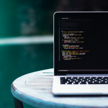 A Macbook open with code on the screen